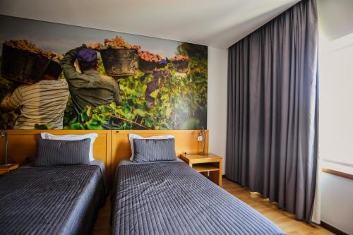 Casal Comba的住宿－Burguezia do Leitão，墙上画画的房间里设有两张床