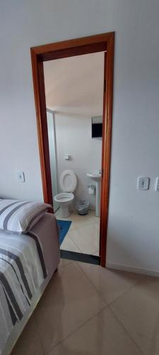 a bedroom with a bed and a bathroom with a toilet at Hostel aiuruoca in Aiuruoca
