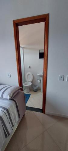 um quarto com uma cama e um banheiro com vaso sanitário em Hostel aiuruoca em Aiuruoca