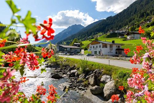 a river with flowers in front of a mountain at Val Monte in Kappl