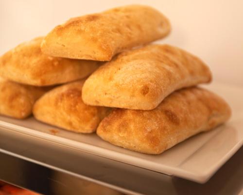 a pile of bread on a white plate at Hotel 19-30 Valencia in Valencia