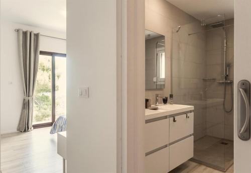 uma casa de banho branca com um lavatório e um chuveiro em Exclusive Villa at La Sella Resort em Pedreguer