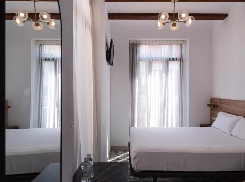 a bedroom with two beds and a mirror at Hotel 19-30 Valencia in Valencia