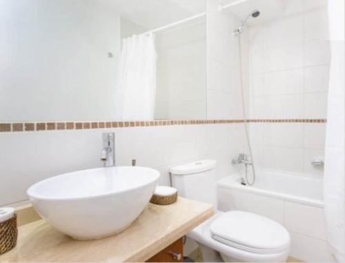 een witte badkamer met een wastafel en een toilet bij SyS Suites Nueva San Martin in Santiago