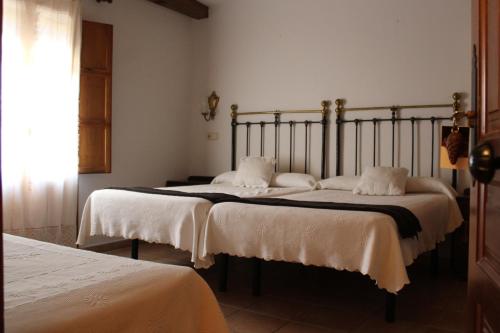 a bedroom with two beds with white sheets at Hotel La Villa in Requena