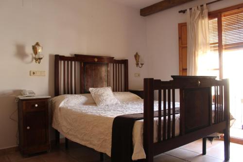 a bedroom with a bed with a wooden headboard at Hotel La Villa in Requena