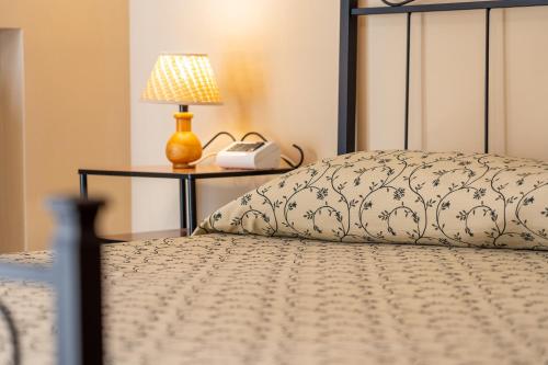 a bed with a phone and a lamp on a table at Hotel Trasimeno in Passignano sul Trasimeno