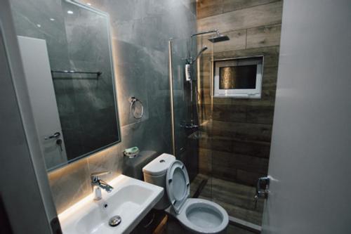 y baño con aseo, lavabo y ducha. en Novs Hotel Rooms en Gjirokastër