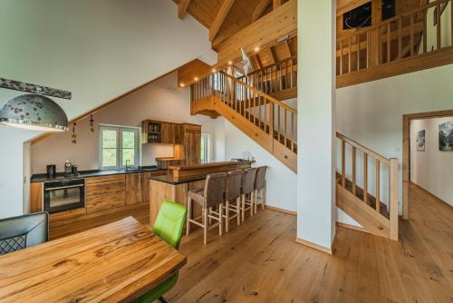 a kitchen and dining room with wooden floors and stairs at Penthouse Weiglhof in Russbach am Pass Gschütt