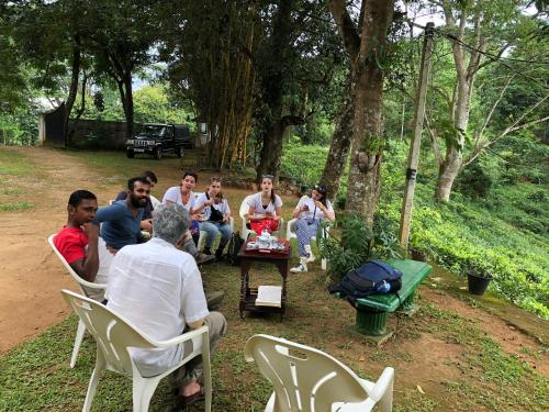a group of people sitting in chairs in a park at Captain's Bungalow, Kandy in Arawwawala
