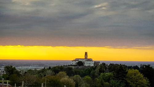 a building on a hill with a sunset in the background at Pie Castello in Susegana