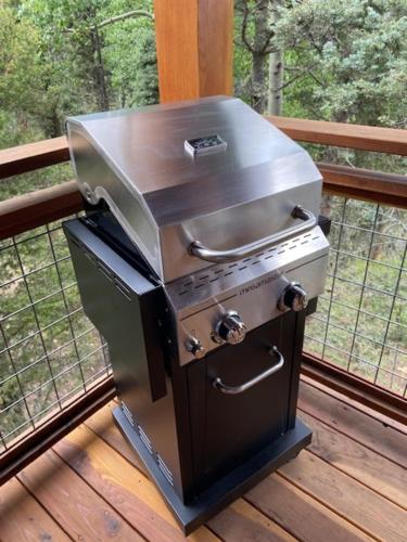 a barbecue grill on a deck on a porch at RidgeWalk Treehouse in Angel Fire