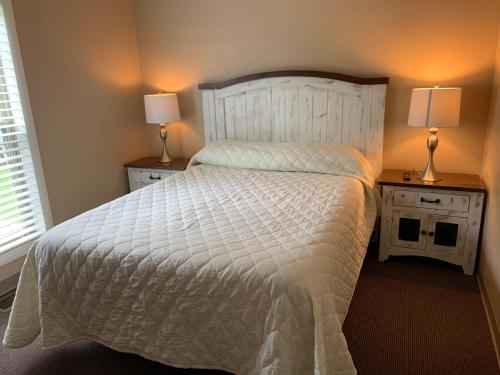 a bedroom with a white bed with two night stands at Carr's Northside Hotel and Cottages in Gatlinburg