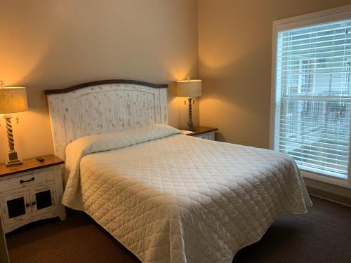 a bedroom with a white bed and a window at Carr's Northside Hotel and Cottages in Gatlinburg