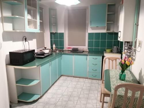 a kitchen with blue cabinets and a table at Grzyminska in Szczecin