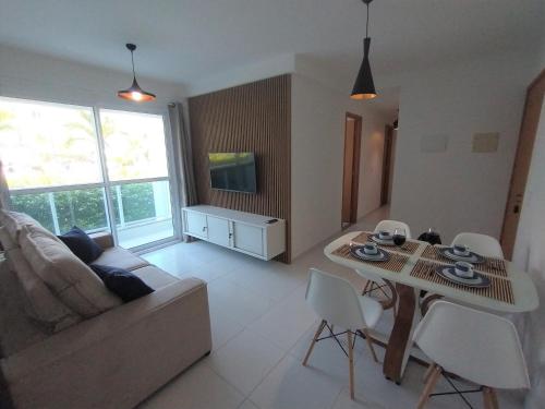 uma sala de estar com um sofá e uma mesa em Palm Village Acqua - Apartamento Premium - Em frente à piscina - Porto de Galinhas em Porto de Galinhas