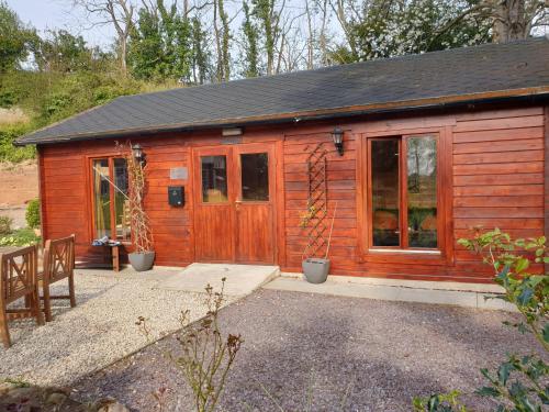 a small wooden cabin with a door and windows at Rustic Retreat in Retford in Retford