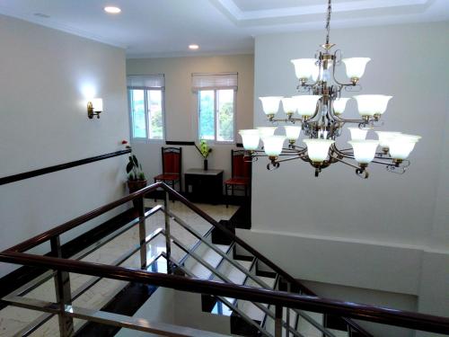 a staircase with a chandelier in a building at Venezia Suites Hotel Iloilo in Iloilo City