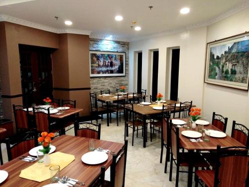 a dining room with wooden tables and chairs at Venezia Suites Hotel Iloilo in Iloilo City