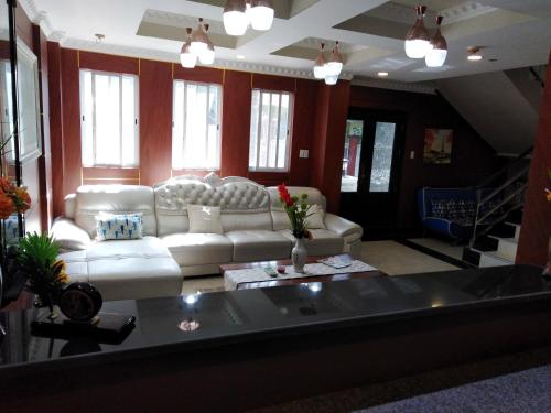 a living room with a white couch and windows at Venezia Suites Hotel Iloilo in Iloilo City