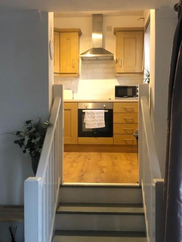 a kitchen with a staircase leading up to a kitchen at Central Lisburn Duplex Apartment No Parties in Lisburn