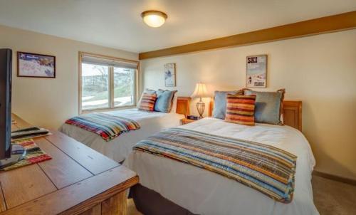 um quarto com 2 camas e uma secretária com uma televisão em Bear Claw 203 - Bear Claw I Building em Steamboat Springs