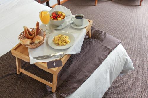 a breakfast tray with breakfast foods on a bed at Hotel Unu in Huancayo