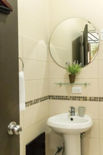 a bathroom with a sink and a mirror at Terida Airport B&B in Alajuela City