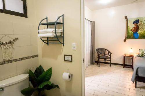 a bathroom with a bath tub and a bedroom at Terida Airport B&B in Alajuela City