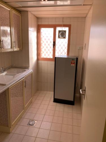 a kitchen with a refrigerator and a sink at Top Hotel Apartments in Al Ain