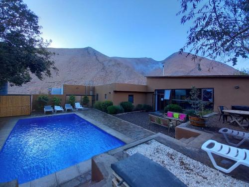 a house with a swimming pool in front of a mountain at Ruta Elqui in Pisco Elqui