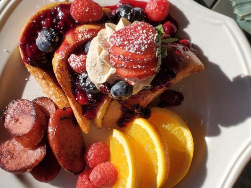 a plate of french toast with fruit and powdered sugar at Hearthside Inn in Bar Harbor