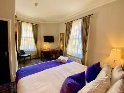 um quarto com uma cama grande e um sofá em The Red Cow - Guest House em Richmond upon Thames