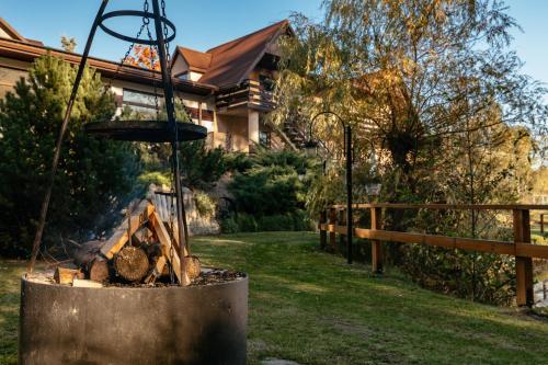 a fire pit in a yard next to a house at Wypoczynek u Piotra z jacuzzi in Susiec