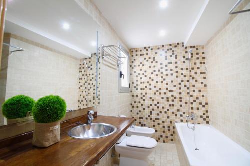 a bathroom with a sink and a toilet and a tub at Atico junto a la Catedral in Tarragona