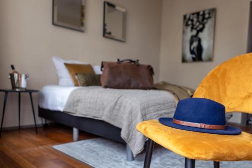 a bedroom with a bed with a blue hat on a chair at Boutique Hotel No5 in Bergen op Zoom