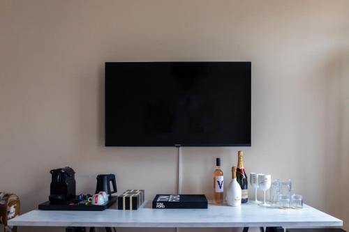a white table with a television on a wall at Boutique Hotel No5 in Bergen op Zoom