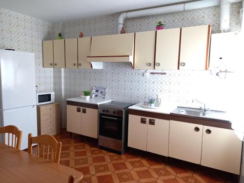 a kitchen with white cabinets and a sink and a table at PISO AMPLIO A 100 M DE LA PLAYA in Foz