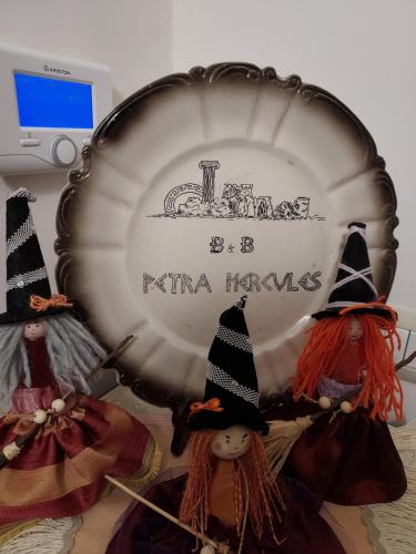 two figurines of witches standing in front of a plate at B&B Petra Hercules in Torre Annunziata