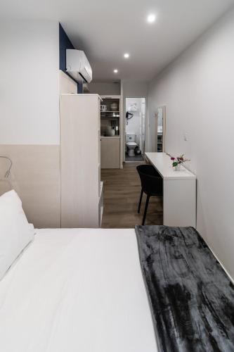 - une chambre avec un lit blanc et un bureau blanc dans l'établissement Residence le Pastel Jeanne d'Arc, à Toulouse