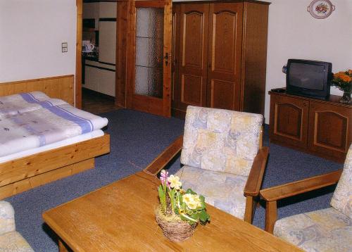 Una sala de estar con una cama, una mesa y sillas. en Palfnerhof Appartements, en Sankt Johann im Pongau