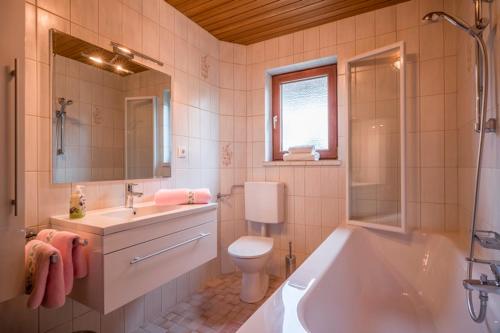 a bathroom with a tub and a toilet and a sink at Ferienwohnung Böck in Kiefersfelden