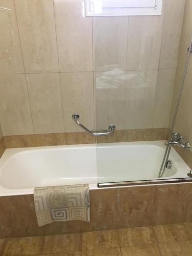 a white bath tub with a shower curtain at Coloma Apartments Pefkos in Pefki
