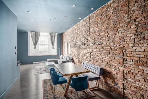 a room with a brick wall and a table and chairs at Boutique Lofts Notre Dame - Vieux Montréal in Montréal