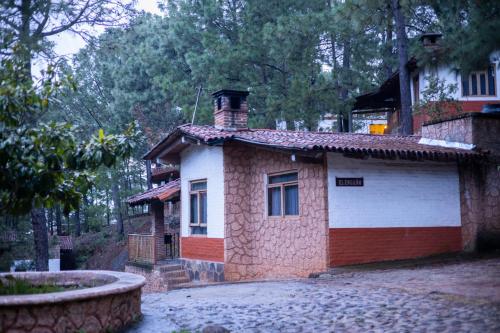a small brick house with a red and white garage at Cabañas RuizSeñor in Mazamitla