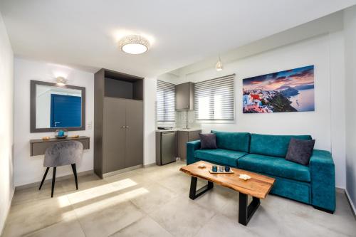 a living room with a blue couch and a table at Honeymoon Beach Studios in Perivolos