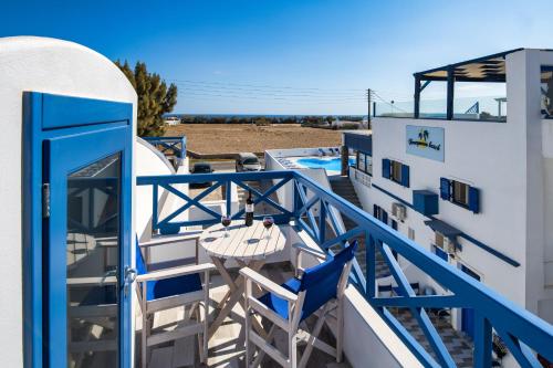 a balcony with a table and chairs next to a building at Honeymoon Beach Studios in Perivolos