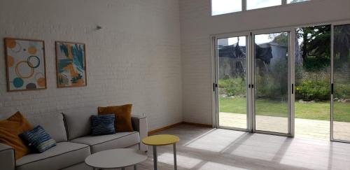 a living room with a couch and tables and sliding glass doors at RANTALOMA Lofts in Piriápolis