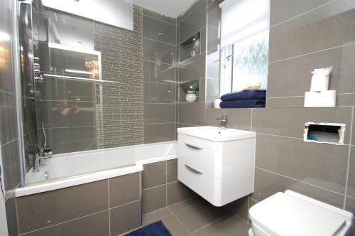 a bathroom with a toilet and a sink and a shower at Mosspark Luxury House in Govan