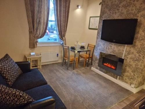 a living room with a couch and a fireplace at Carlisle City Centre, Cute Victorian House. in Carlisle